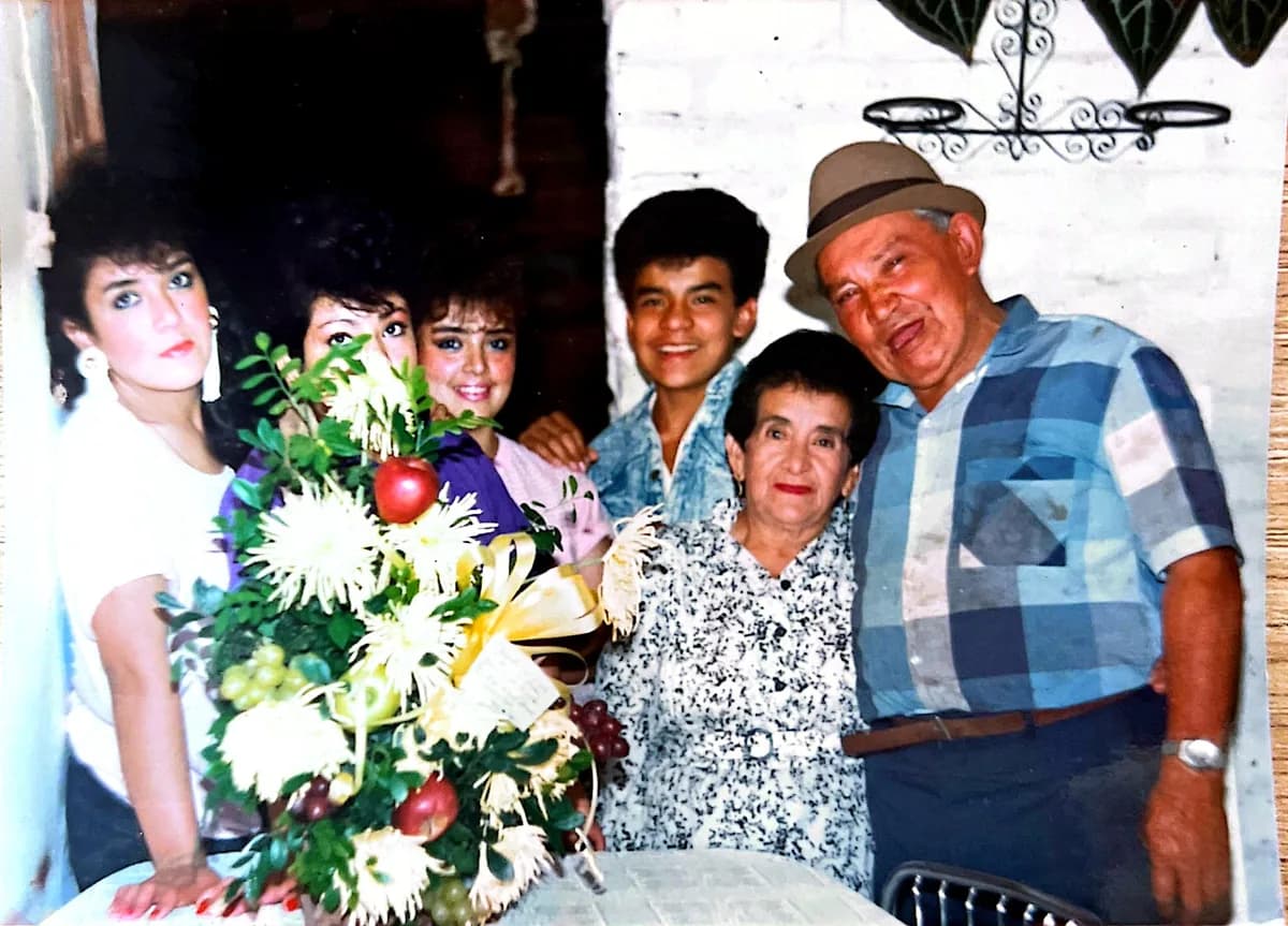 Fotografía antigua: familia reunida alrededor de un gran ramo de flores